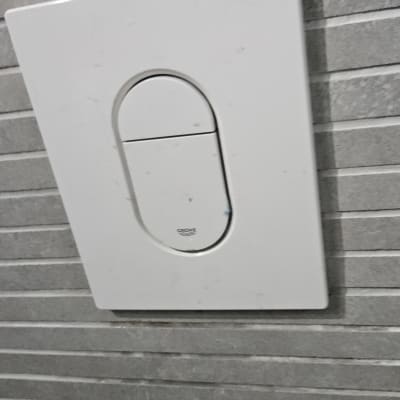 לחצן הדחה על קיר אריחים אפור