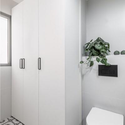 ארון לבן עם ידיות שחורות, אסלה וצמח ירוק