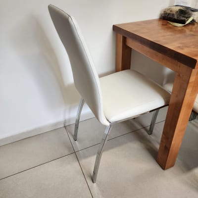 כיסא מרופד לבן ליד שולחן עץ