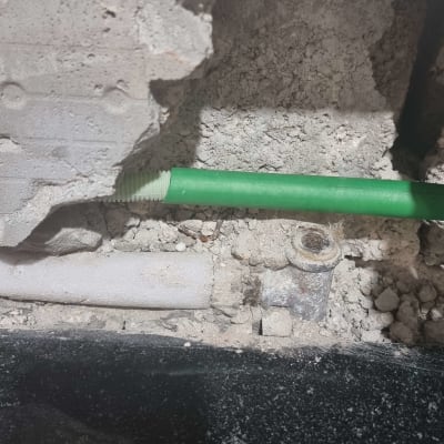 צינור ירוק בקיר חשוף עם חיבורים