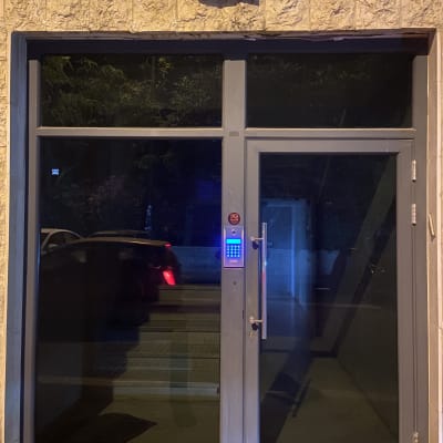 דלת כניסה עם מערכת אינטרקום מוארת בלילה