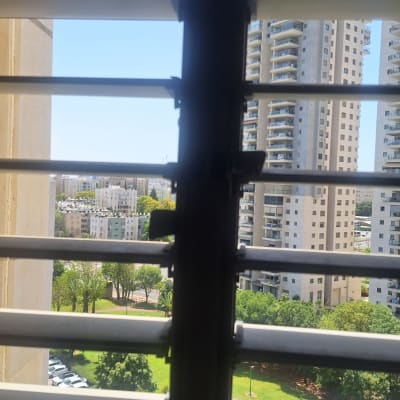 תריסים אופקיים פתוחים עם נוף עירוני ברקע