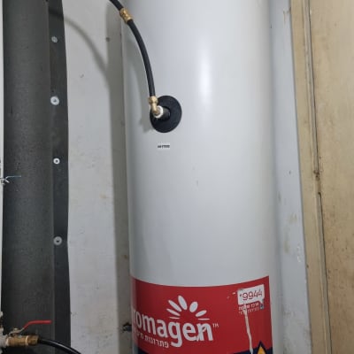 דוד שמש לבן עם צינור מחובר לקיר