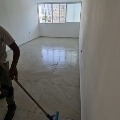 אדם מנקה רצפה בחדר ריק עם חלון גדול
