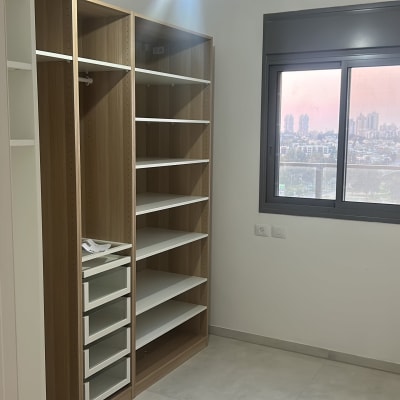 ארון מדפים בחדר עם חלון ונוף עירוני