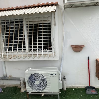 יחידת מזגן חיצונית מותקנת על קיר לבן