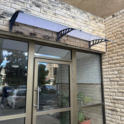 סוכך אלומיניום מעל דלת זכוכית בבניין