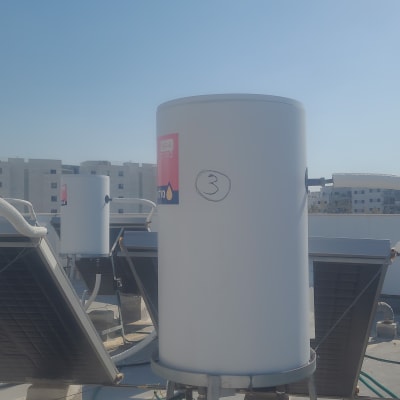 דוד שמש לבן עם צינורות וחיבורים על גג