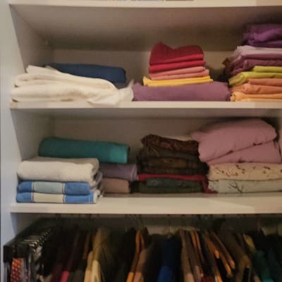 מדפים עם בגדים מקופלים ומעילים תלויים בארון