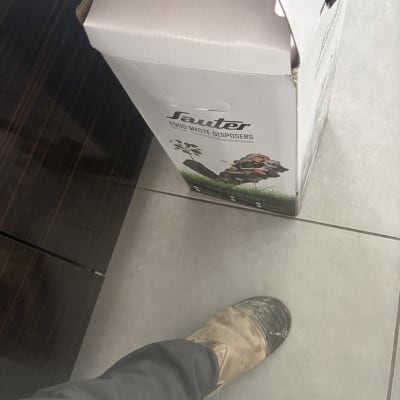 קופסת מפסק אשפה על רצפה עם נעל עבודה