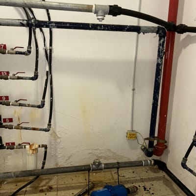 צינורות מים, שסתומים וכלי עבודה על הרצפה