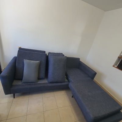 ספה כחולה עם כריות על רצפת אריחים