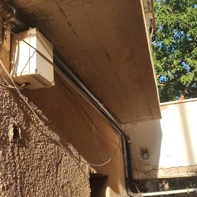 תמונה של קיר חיצוני עם צינורות וחוטים