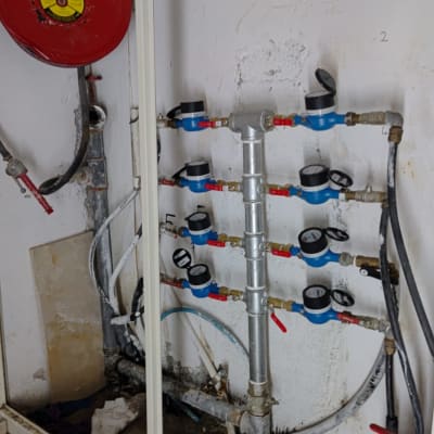 מערכת צינורות ומדי מים על קיר לבן