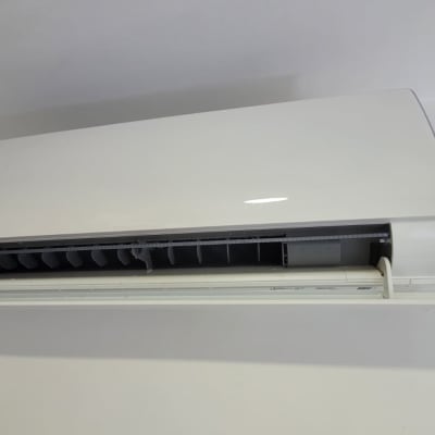 מזגן קיר לבן עם תריסים פתוחים