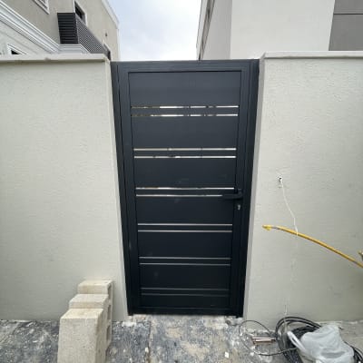 שער אלומיניום שחור עם קיר בטון