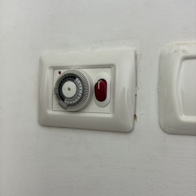 מתג חשמלי עם טיימר על קיר לבן