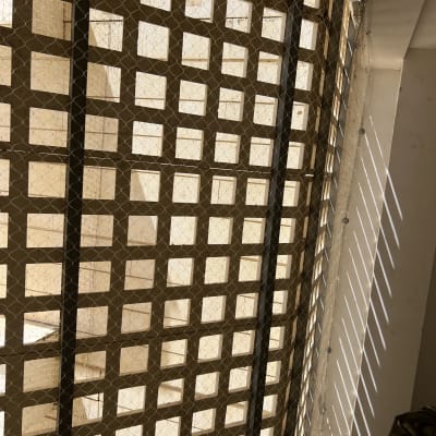 רשת מתכת מותקנת על חלון למניעת כניסת יונים