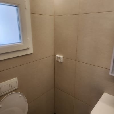 חדר שירותים עם אסלה וקיר מרוצף