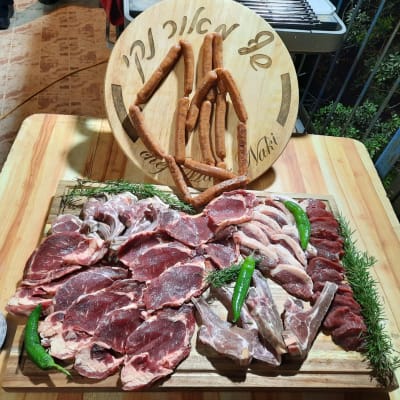 מגש בשר טרי עם נקניקיות על שולחן עץ