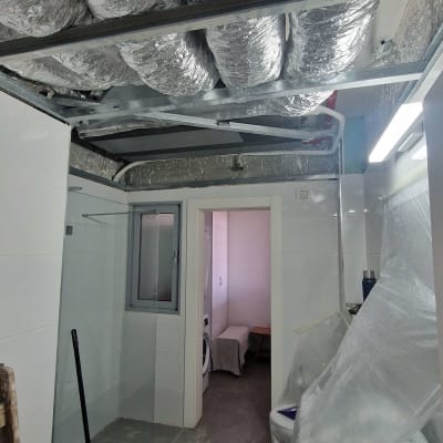 תעלות אוורור מותקנות בתקרה בחדר אמבטיה
