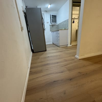 רצפת פרקט בחדר עם מקרר וארונות מטבח