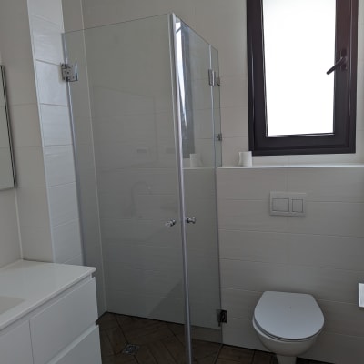 מקלחון זכוכית עם דלתות שקופות בחדר אמבטיה