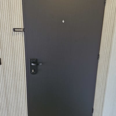 דלת מתכת כהה עם ידית ומנעול