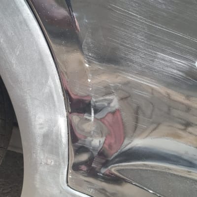 נזקי שריטות ושקעים על דלת רכב שחורה