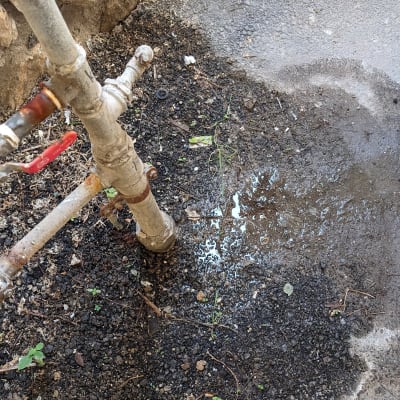 צינור מים דולף על אדמה רטובה