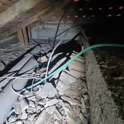 צינורות וחוטים בעליית גג עם פסולת בנייה