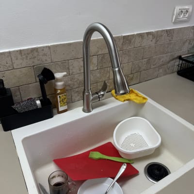 כיור מטבח עם כלים מלוכלכים וברז נירוסטה