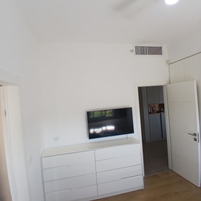 חדר עם קיר לבן, טלוויזיה ומזגן