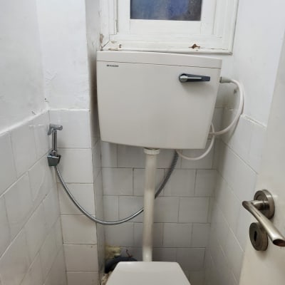 אסלה ומיכל הדחה בחדר שירותים קטן