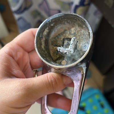 חלק מתכת חלוד, ייתכן שקשור לאינסטלציה, מוחזק ביד.