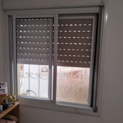 תריסים לבנים עם חריצים פתוחים בחלון