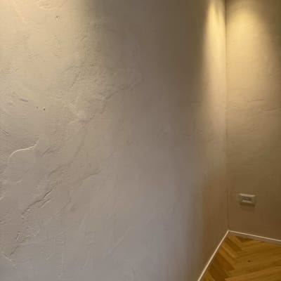 קיר צבוע עם תאורה עליונה ורצפת עץ