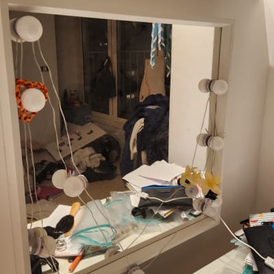 מראה עם נורות, מברשת וכלי טיפוח על השולחן