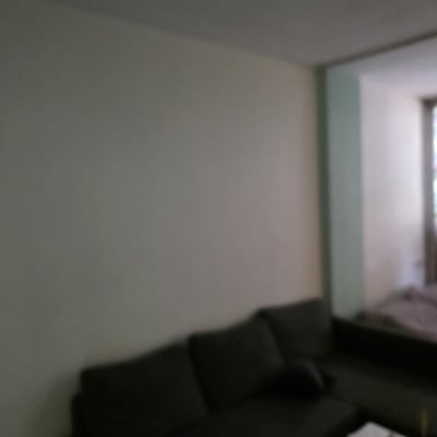 קיר צבוע בסלון עם ספה כהה