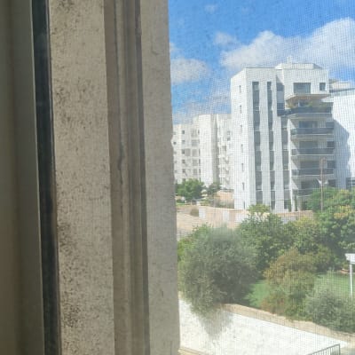 חלון מלוכלך עם נוף לבניינים ברקע