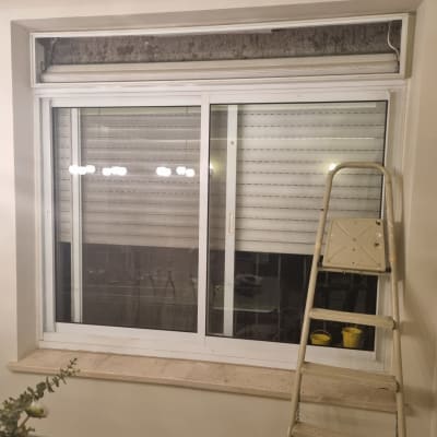 תריסים לבנים סגורים עם חלון זכוכית ומדרגות ליד