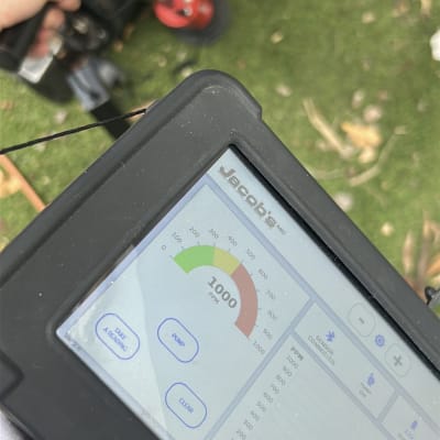 מכשיר מדידה עם תצוגה דיגיטלית על דשא