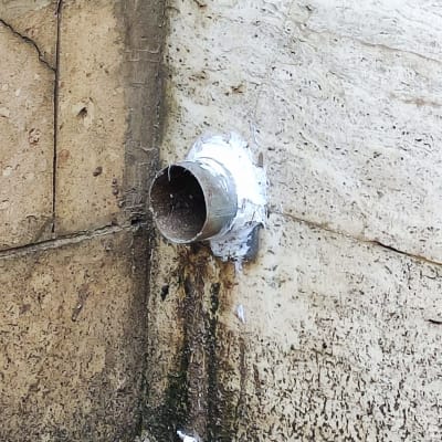 צינור מתכת בולט מקיר עם סימני רטיבות