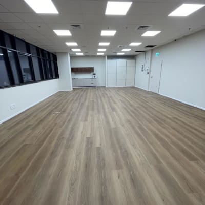 רצפת פרקט עץ בחדר מואר עם תקרה לבנה