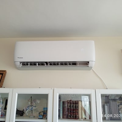 מזגן מותקן על קיר מעל ארון זכוכית