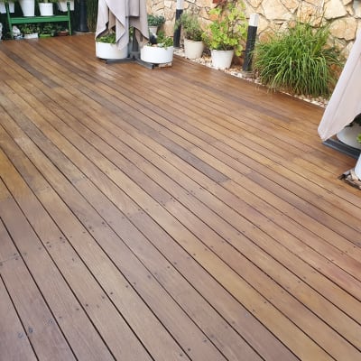 דק עץ עם עציצים ופרגולות בגינה