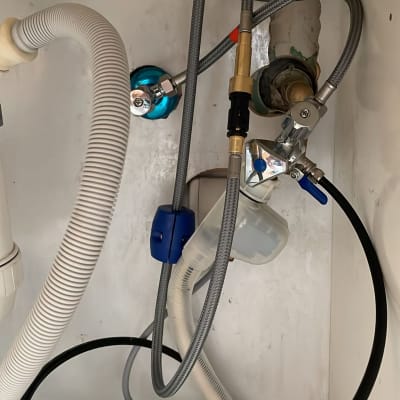 צינורות מים מתחת לכיור עם ברזים וחיבורים