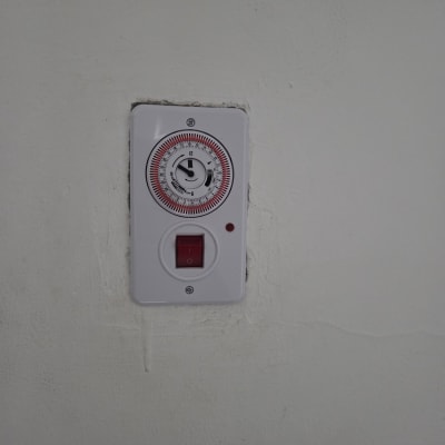 שעון טיימר חשמלי מותקן על קיר לבן
