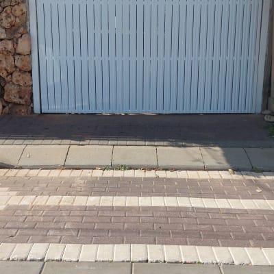 שער מתכת לבן עם שביל מרוצף מלפנים