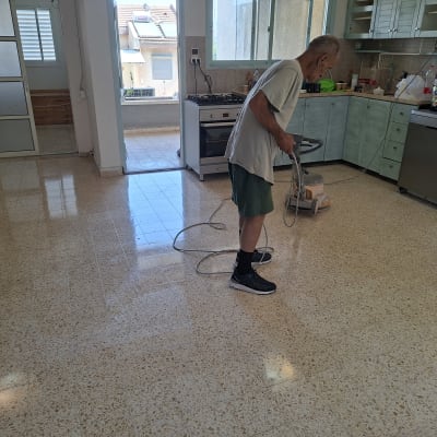 אדם מנקה רצפה במכונת פוליש במטבח